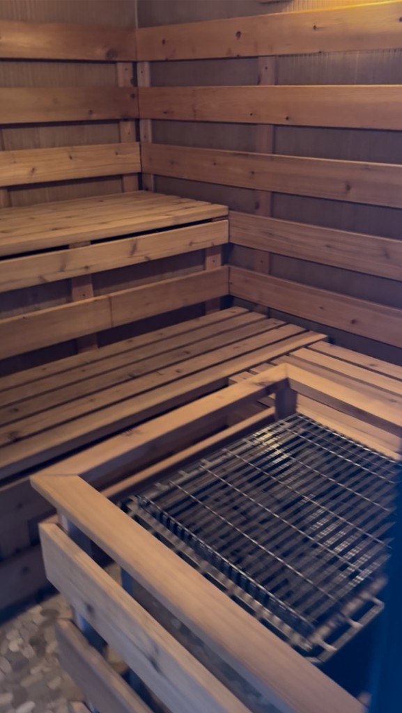 Sauna interior with warm cedar benches and heater.